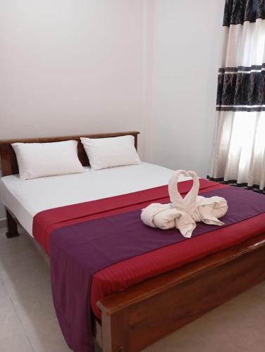 a bedroom with a bed with a ribbon on it at Ceylon Seaway Villa in Trincomalee