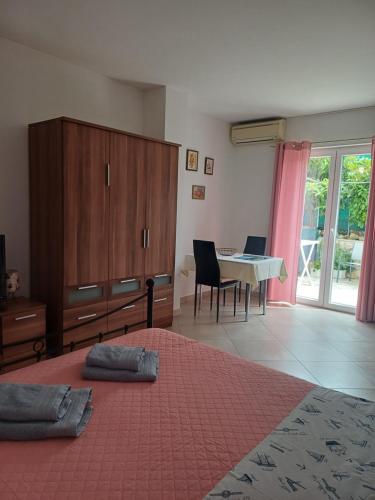 a bedroom with a large bed and a table with chairs at Studio Apartment Ivo in Cres
