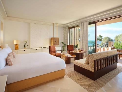 a bedroom with a large bed and a living room at Mandarin Oriental Punta Negra, Mallorca in Palmanova