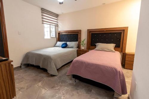 a bedroom with two beds and a window at Casa independencia in Morelia