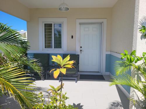 a porch with a white door and a couch at Beit Elohim in Lucea