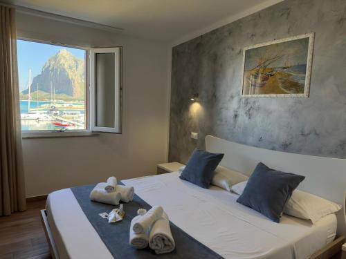 a bedroom with a large bed with towels on it at Il vecchio e il mare in San Vito lo Capo