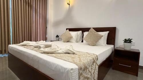 a bedroom with a bed with white towels on it at Solar Airport Hotel in Seeduwa