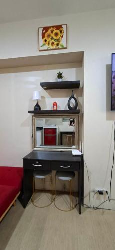 a desk in a room with a red bed at Avida Towers Aspira Studio Condo in Cagayan de Oro