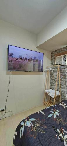 a bedroom with a flat screen tv on the wall at Avida Towers Aspira Studio Condo in Cagayan de Oro