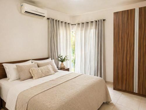 a bedroom with a large bed and a window at Shamballa - luxury house and apartments in São Miguel do Gostoso