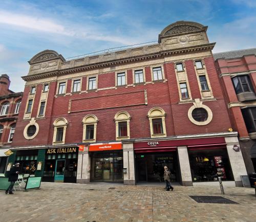 a large red brick building on a city street at easyHotel Leeds in Leeds