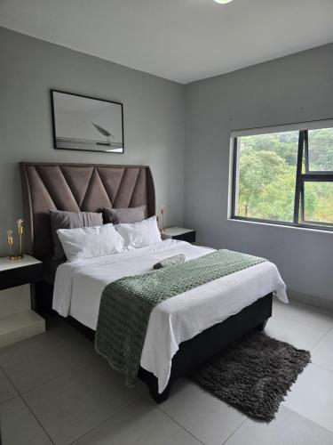 a bedroom with a large bed and a window at WeThusiCBD in Mbabane