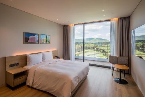 a hotel room with a bed and a large window at ILLITE Hotel in Yŏngdong