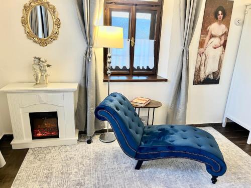 a blue chair in a living room with a fireplace at Antik Vendégház in Nagyvisnyó
