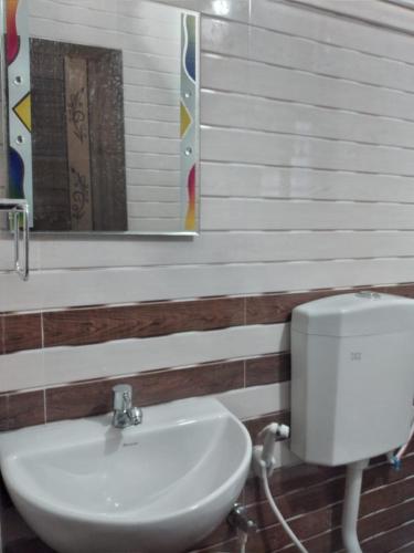 a bathroom with a white sink and a mirror at Samudra Nadi Bliss in Mūlki