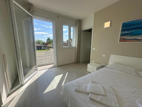 a bedroom with a white bed and a large window at Locanda Patoea Alloggi in Borgoricco