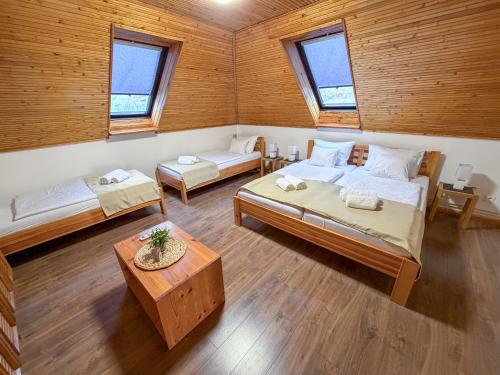 a large room with two beds and a table at Bolla Nyaralóház in Hegyhátszentjakab