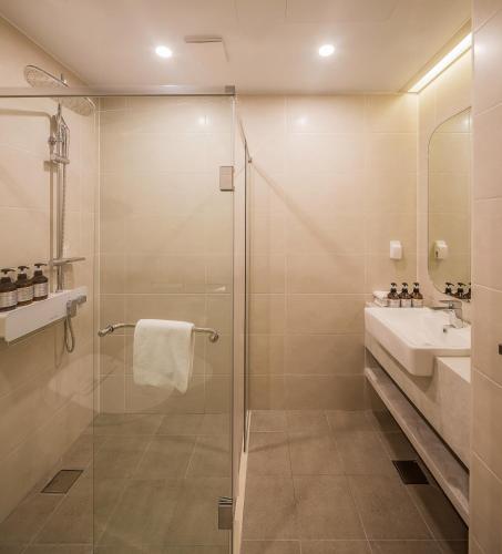 a bathroom with a shower and a sink at ILLITE Hotel in Yŏngdong