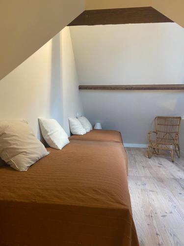 a bedroom with two beds and a chair at Annasroom in Kortrijk