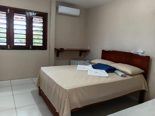 a bedroom with a bed and a window at Suítes Maanaim Flecheiras in Flecheiras