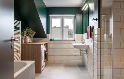 ein Badezimmer mit grünen Wänden, Badewanne und Waschbecken in der Unterkunft ipartment Berlin Mitte HOME by Best Western in Berlin