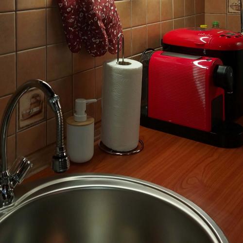 a sink with a roll of paper towels and a toaster at Napsugár Vendégház Nagylóc in Nagylóc