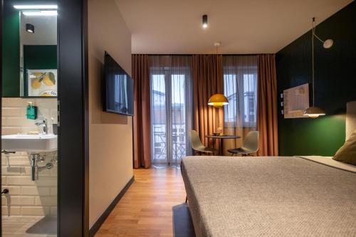 ein Schlafzimmer mit Bett, Waschbecken und Badezimmer in der Unterkunft ipartment Berlin Mitte HOME by Best Western in Berlin