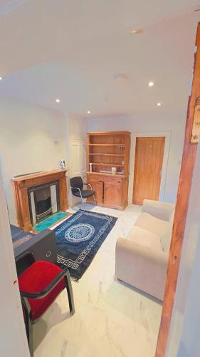 a living room with a couch and a fireplace at Meadow room in Slough