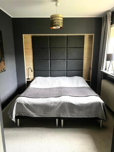 a bedroom with a large bed with a black headboard at Villa med Pool in Stockholm