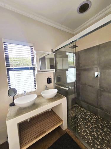 a bathroom with two sinks and a glass shower at Fairfax Studio in Nottingham Road