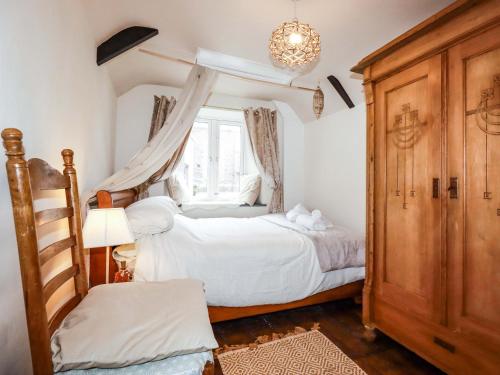 a bedroom with a bed and a window at Sunnybrae Cottage in Tintagel