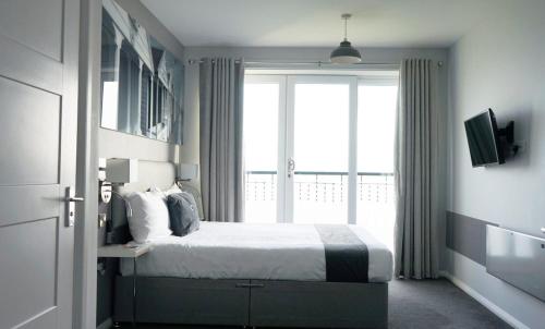 a bedroom with a bed and a large window at The Harbour Post at Waterside Park in Corton