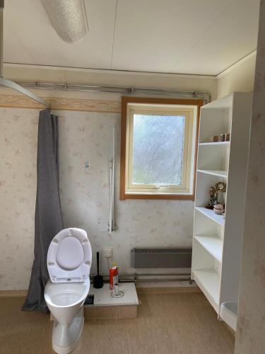 a bathroom with a toilet and a window at Central Villa Hultsfred Vimmerby in Hultsfred