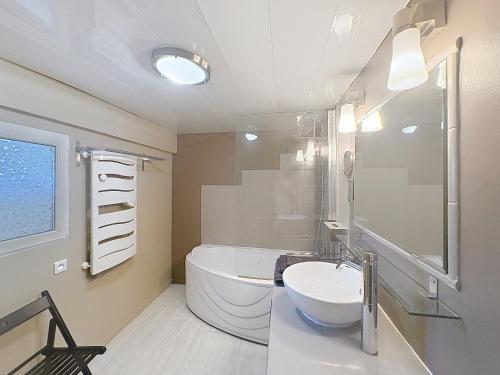 a bathroom with a sink and a tub and a toilet at La Petite Riau in Seillonnaz