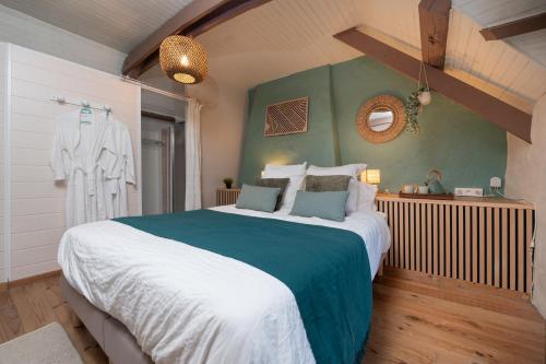 a bedroom with a large bed and a green wall at Ty Kerouannec in Guilligomarcʼh