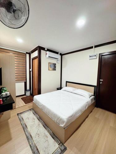 a bedroom with a large bed and a fan at Rumah Kebun Gucher in Kuala Terengganu