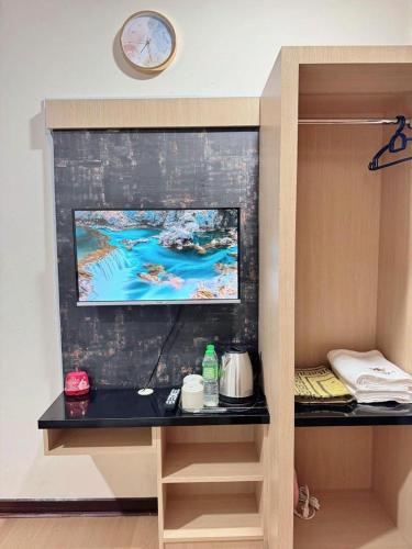 a tv on a wall in a room at Rumah Kebun Gucher in Kuala Terengganu