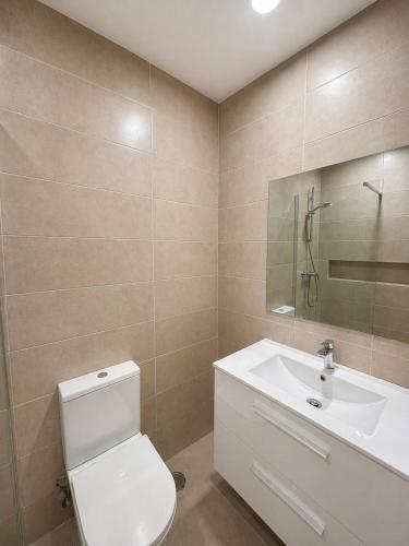 a bathroom with a white toilet and a sink at Casa do Picadeiro in Elvas