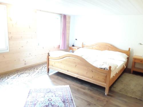 a wooden bed in a room with a window at DesAlpes in Saxeten