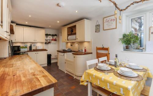 a kitchen with a table with a yellow table cloth on it at 1 Apse Castle Cottage - Chocolate Box Cottage, Pet-Friendly 16th Century Cottage, surrounded by Ancient Woodland in Shanklin in Shanklin