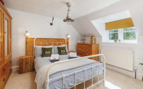 a bedroom with a wooden bed and a window at 1 Apse Castle Cottage - Chocolate Box Cottage, Pet-Friendly 16th Century Cottage, surrounded by Ancient Woodland in Shanklin in Shanklin