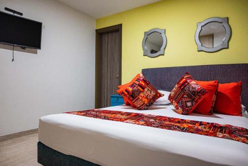 a bedroom with a bed with colorful pillows on it at Hotel Veneton Dosquebradas in Dosquebradas