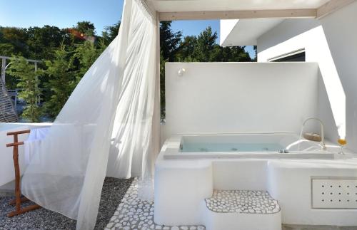 ein weißes Badezimmer mit Badewanne und Waschbecken in der Unterkunft Olympa Suites in Plaka