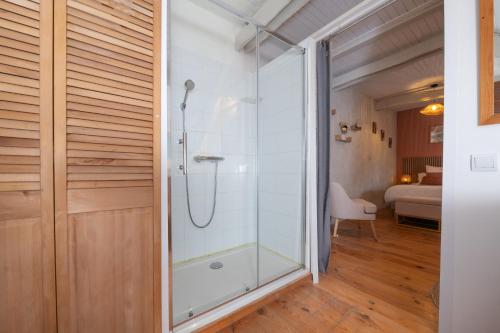 a bathroom with a shower and a glass door at Ty Kerouannec in Guilligomarcʼh