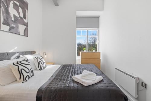 a bedroom with a bed and a window at The Loft - Properties Unique in Newcastle upon Tyne