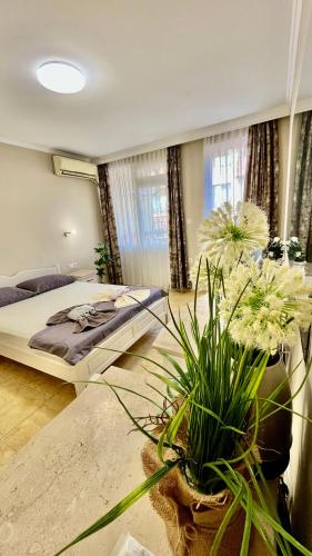 a bedroom with a large bed and some plants at Fener Guest House in Pomorie