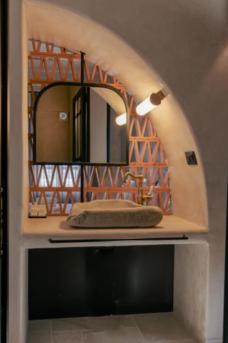 a bathroom with a mirror on top of a sink at Meroviglia Boutique Hotel in Imerovigli