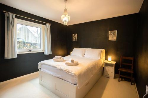 a bedroom with a white bed with a window at 54a Albert Street, Kirkwall, Orkney - OR00603F in Kirkwall