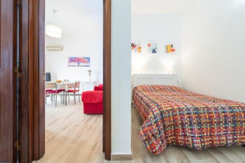 a bedroom with a bed and a red chair at Appartamento il Decimomiglio in Decimomannu