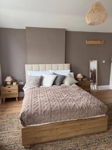 a bedroom with a large bed and a mirror at Glan Neigr Room 11 in Rhosneigr