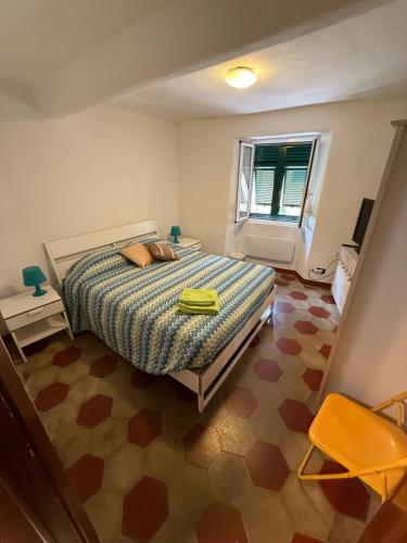 a bedroom with a bed and a window at Appartamenti La Quiete in Mele