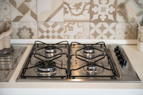 a stove top with three burners on a kitchen counter at Appartamento il Decimomiglio in Decimomannu