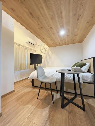 a bedroom with a bed and a table and a chair at Shinjuku Topshot Hotel in Tokyo