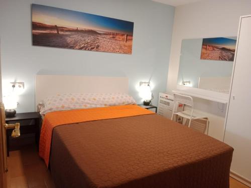 a bedroom with a bed with an orange blanket at Loft Centrico Bahia 2 in Santander